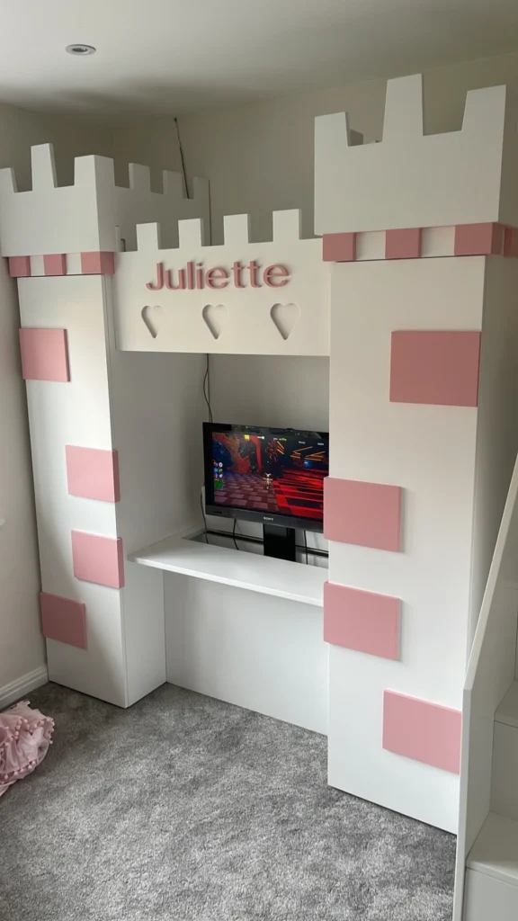 Childrens desk in a castle style with wardrobes either side and a pop up tv